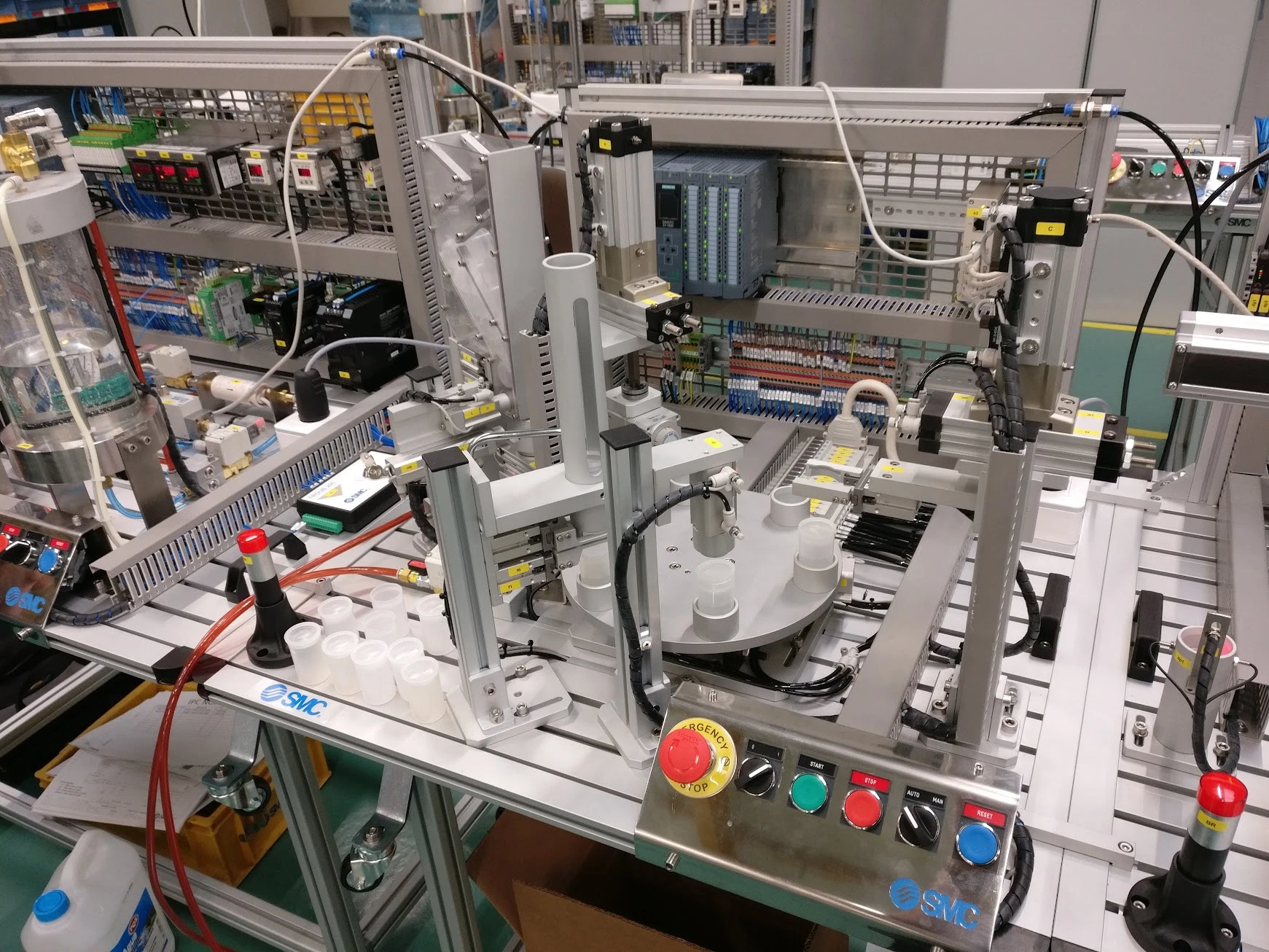 Automated IPC bottling station for the Oslo installation, showing a rotary indexing table, bottle dispenser, cap-handling equipment, Siemens PLC and operator controls.