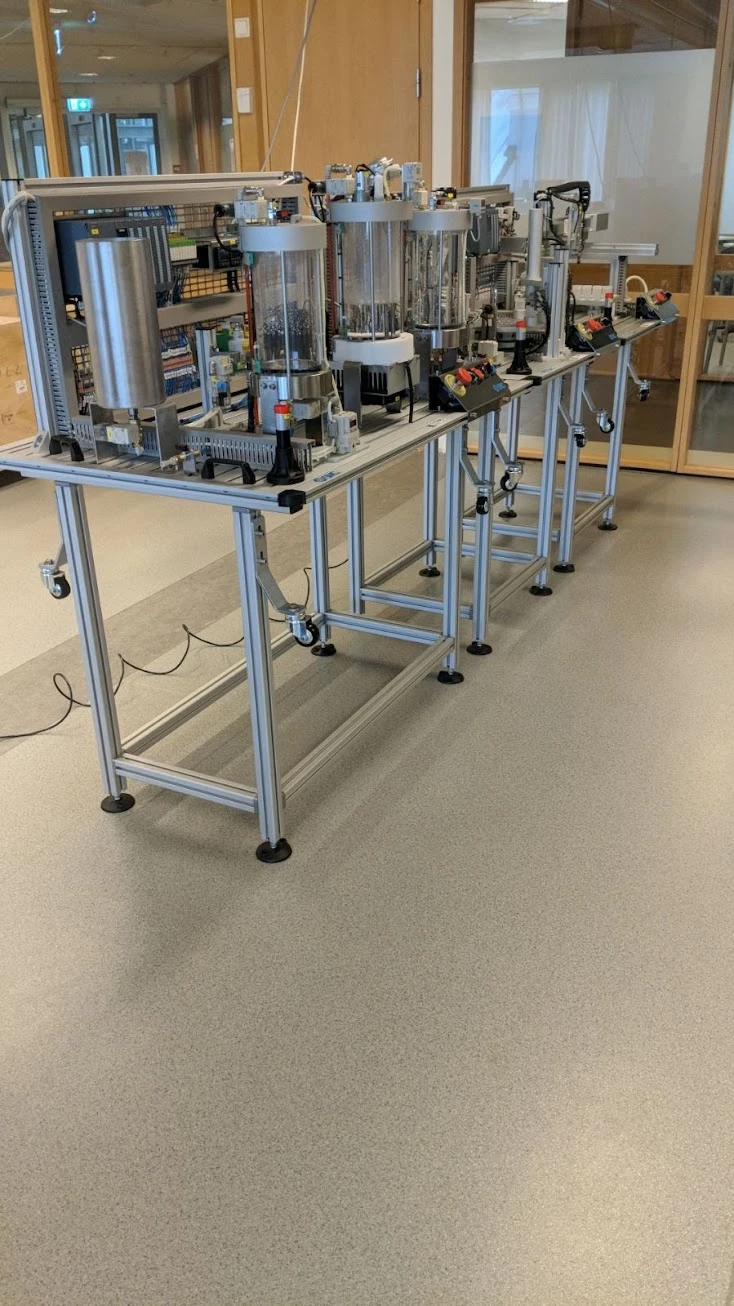 Complete IPC training line installed at Oslo and Akershus University, with process-control vessels, bottling and palletising equipment arranged in the teaching space.