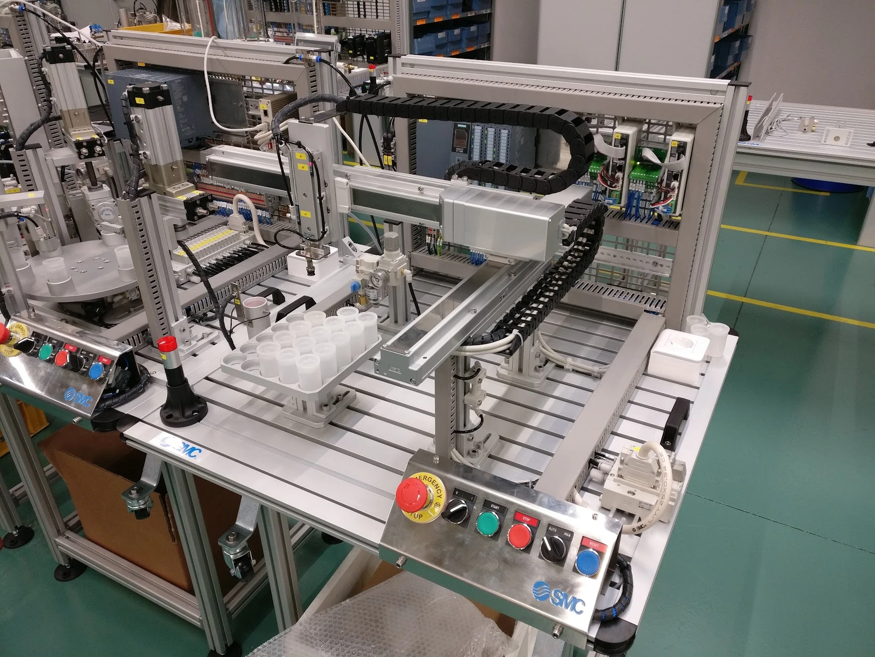 IPC palletising station with a Cartesian pick-and-place robot, bottle receiving position and pallet of bottles beside the automated bottling station.