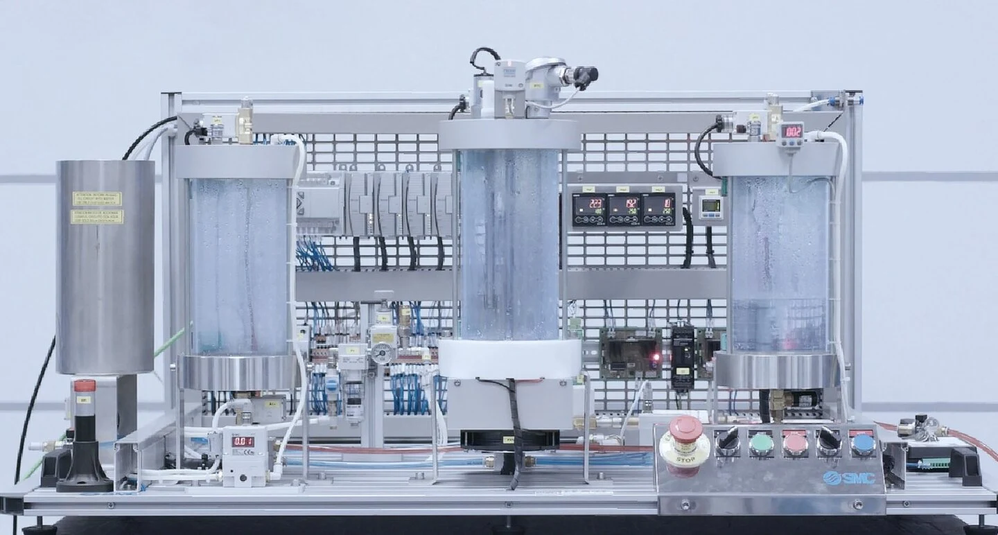 Front view of the IPC201C process station with three vessels and industrial control hardware.