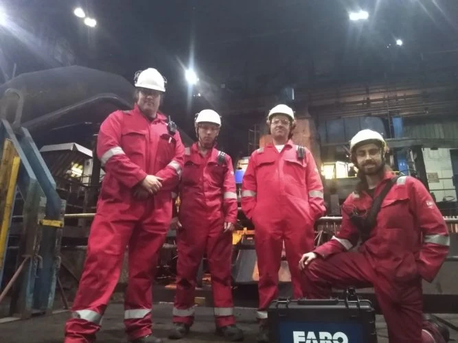 Four members of TSC’s digital team wearing red protective clothing and hard hats beside scanning equipment at Stocksbridge.